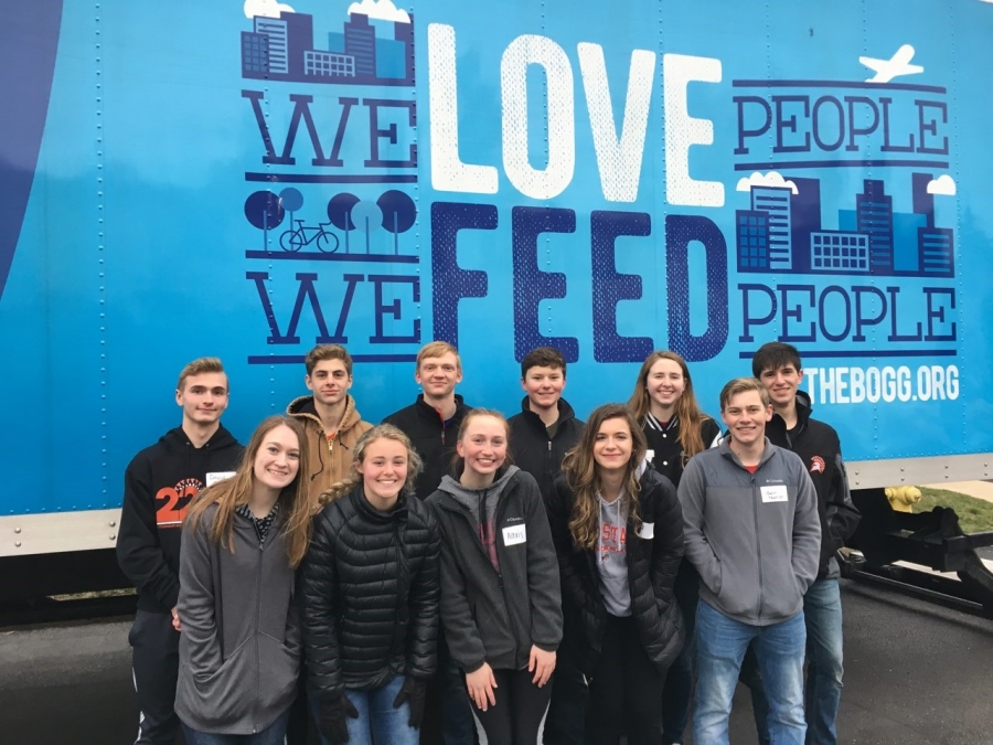 group of students in front of a blue background poster